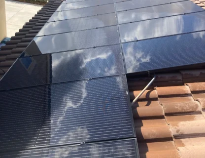 Solar panels reflecting clouds on a rooftop, showcasing pristine clean solutions